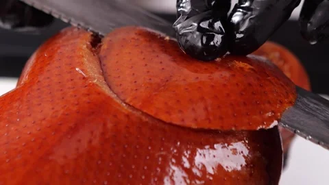Chef masterfully slicing Peking duck tableside 4K Stockbeeldmateriaal 338338950
