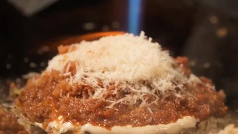 Chef Melting Grated Parmesan Cheese with Blowtorch on Italian Pasta Meat Sauce Stock Footage 333522146