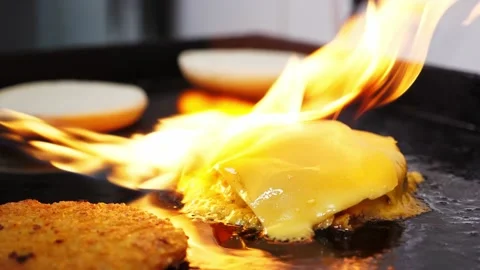 Chef melting processed cheese on meat cutlet with gas burner on grill Stock Footage 153160645
