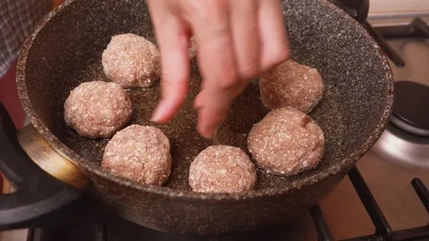 Chef methodically arranges meatballs for optimal searing and cooking 库存影片 331151211