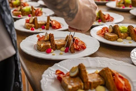 Chef in the midst of plating dishes Stock Photos