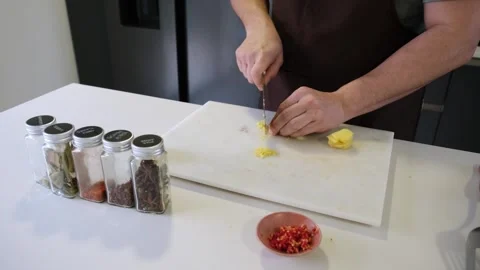Chef mincing fresh ginger on a white cutting board Stock Footage 340220943