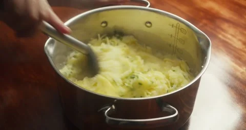 Chef mixes creamy mashed potatoes with grated parmesan cheese and chopped green Vídeo Stock 327622722