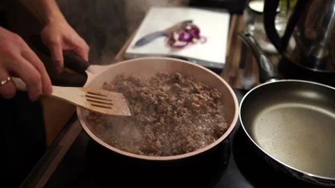 Chef mixes minced meat boiling in oil in a pan with a spatula Stock Footage 276844505