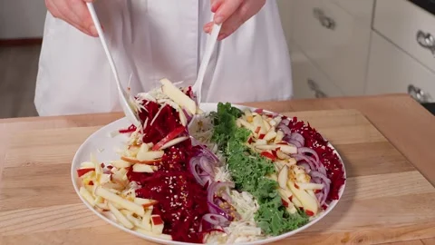 The chef mixes a salad of beets, apples, kale, and onions Stock Footage 265177411