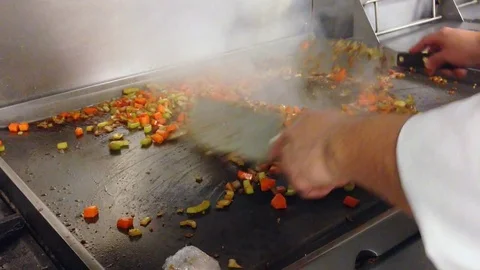 A Chef Mixes Vegetables on Large Grill Stock Footage 73805763