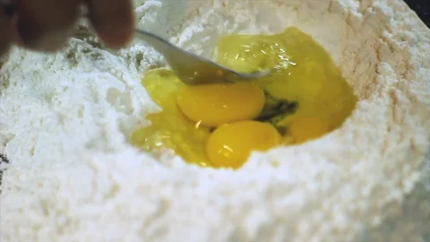 Chef mixing the egg with flour to prepare a dough Stock Footage 101405045