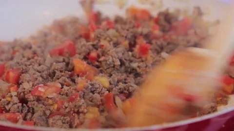Chef mixing frying ground meat with sliced onions and tomatoes on ceramic pan.  Stock Footage 71123043