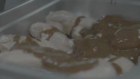 Chef mixing marinated chicken by hand in slow motion. Stockbeeldmateriaal 327353716