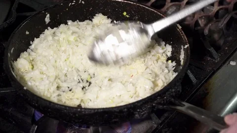 Chef mixing onion while frying on the pan Stock Footage 73621849