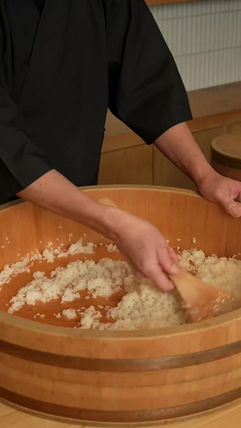 Chef mixing sushi rice in a large wooden bowl Stock-Footage 331770536