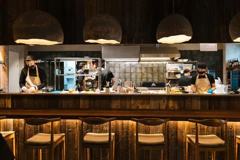Chef in the open kitchen, working at cooking station in the restaurant and cafe Stock Photos