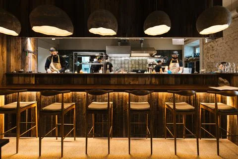 Chef in the open kitchen, working at cooking station in the restaurant and cafe Stock Photos