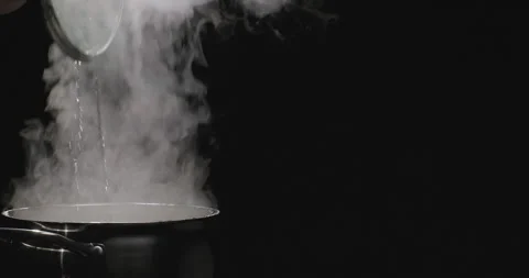 Chef opens the lid of the pan with boiling water. Steam comes out of the Stock Footage 252759053