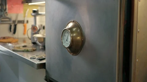 Chef opens the oven and puts a piece of meat in a restaurant kitchen. Stock Footage 92937952