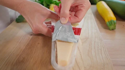 Chef opens a package of Parmesan cheese, wooden dock Stock Footage 266317828