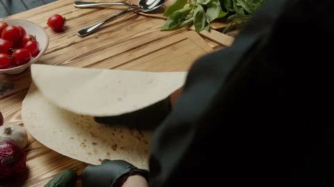 The chef opens pita bread on the table and prepares gyros Stock Footage 156287933