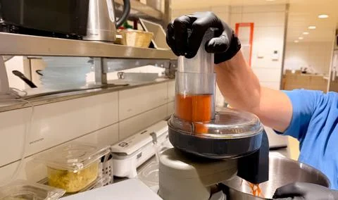 Chef Operating Food Processor With Carrots Inside Bowl While Making Fresh Sal Stock Photos