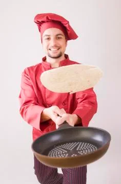 Chef with pan flips pancake Stock Photos