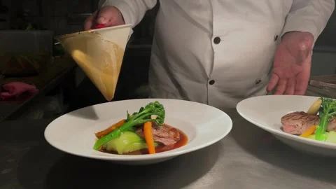 Chef At The Pass Adding Sauce to Dish Stock Footage 244990823