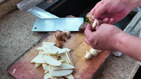 A chef peeling and chopping garlic Stock Footage 314807700