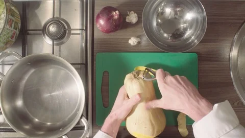 Chef peeling and cutting pumpkin on chopping board Stock Footage 88608843