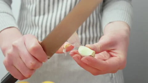 Chef peeling a fresh big garlic clove close-up in 4K. Stock Footage 145998072