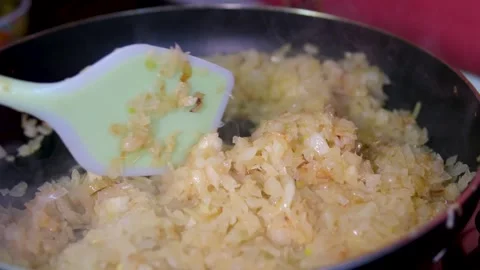 The chef peeling the garlic, The chef stirs the minced garlic with olive oil in Stock Footage 296126429