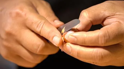 A chef is peeling shallots with a small sharp kitchen knife for preparing t.. Stock Photos