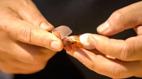 A chef is peeling shallots with a small sharp kitchen knife for preparing t.. Stock Photos