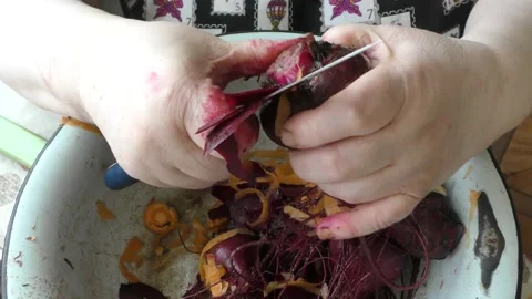 The chef peels boiled beets with a knife Stock Footage 164187171