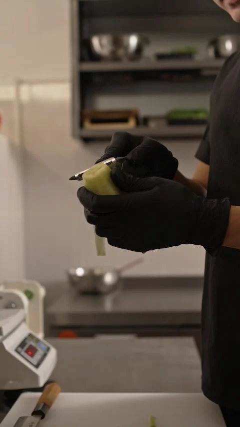 Chef peels a cucumber in close-up while preparing an Asian cuisine dish. Stock-Footage 282784293