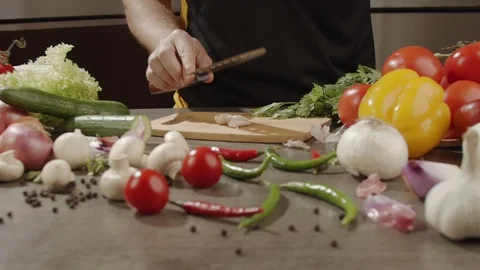 Chef peels the garlic by crushing it with knife. Slow motion video Stock Footage 123957979