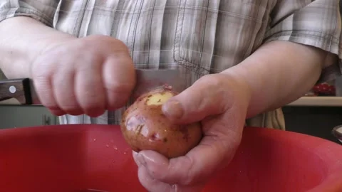 The chef peels a potato with a knife Stock Footage 165612359