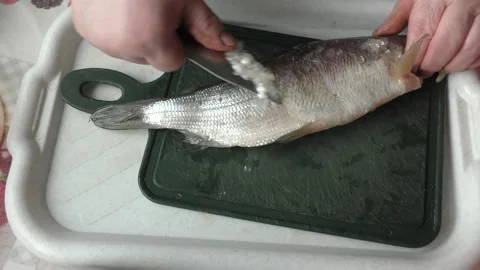 The chef peels raw fish with a knife Stock Footage 166337553