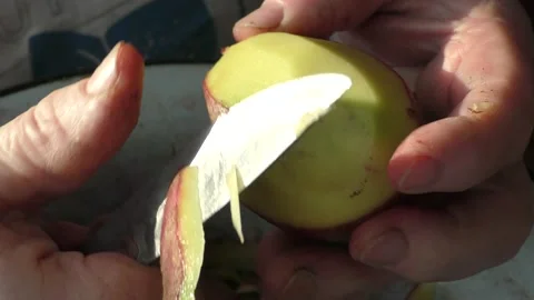 The chef peels raw potatoes with a knife Stock Footage 166333887