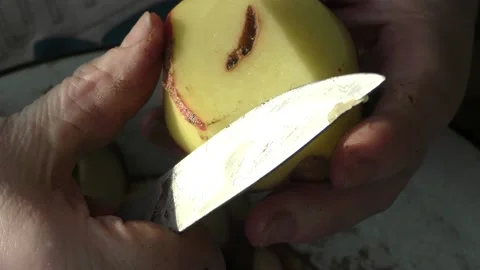 The chef peels raw potatoes with a knife Stock Footage 166334076