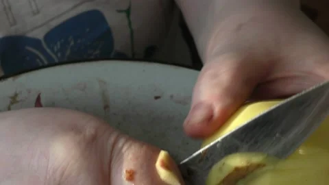 The chef peels raw potatoes with a knife Stock Footage 166334330