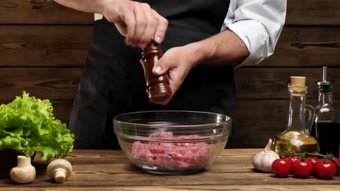 Chef peppers freshly cooked ground beef in a glass bowl Stock Footage 196917037
