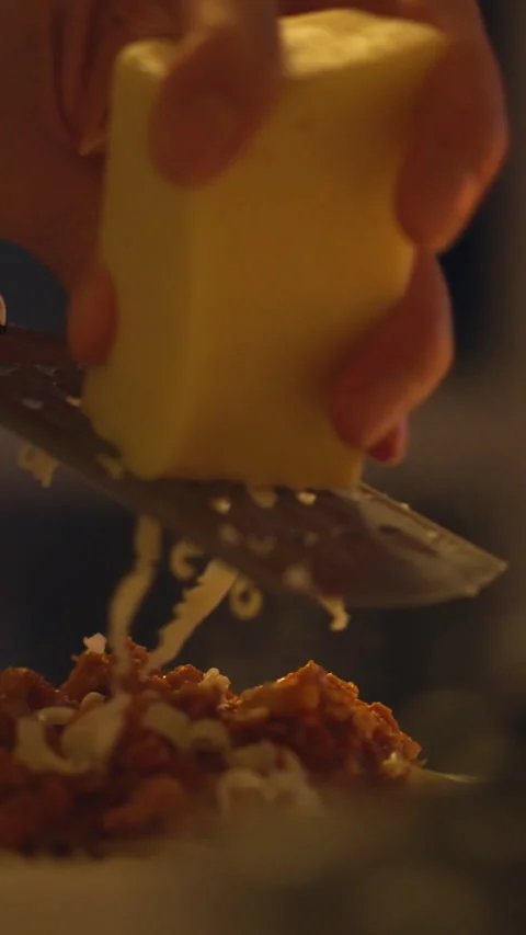 Chef the person preparing the meal grates cheese onto plate of pasta covered Stock Footage 341284038