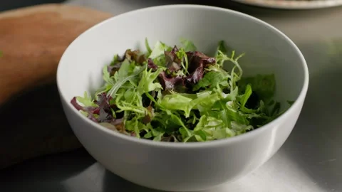 Chef Picking Fresh Salad Greens from a White Bowl Stock Footage 312814971