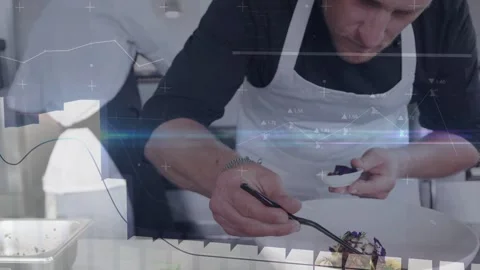 Chef picking garnish from spoon, placing with tongs, finishing dish in kitchen Stock Footage 333689287