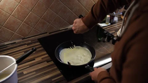 Chef picks up the edges of the pancake with a spatula in a pan Stock Footage 287937833