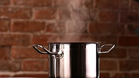 Chef picks up the Lid from the Pan. White Clouds of steam rise from under the Stock-Footage 151119005