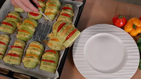 The chef places the cooked zucchini stuffed with cheese and tomatoes on a plate Stock Footage 270150366