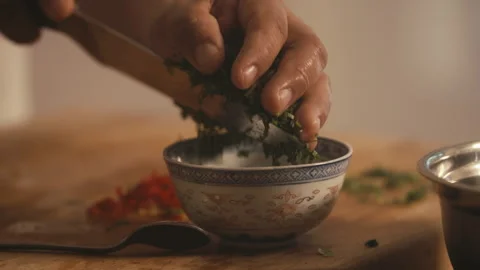 Chef places fresh herbs in small bowl on counter Stock Footage 274619231