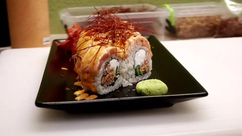 Chef places ginger next to delicious sushi on a plate Stock Footage 285249271