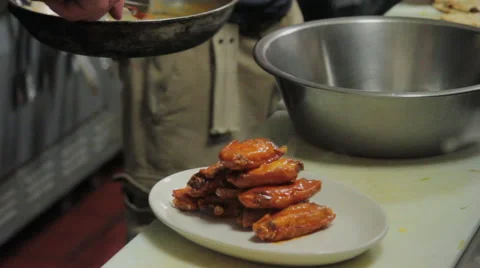 Chef places wings on plate - close-up shot Stock Footage 44114051