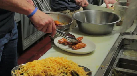Chef places wings on a plate - medium shot Stock Footage 44114058