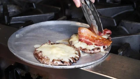 Chef placing bacon on a burger patty 库存影片 203897366